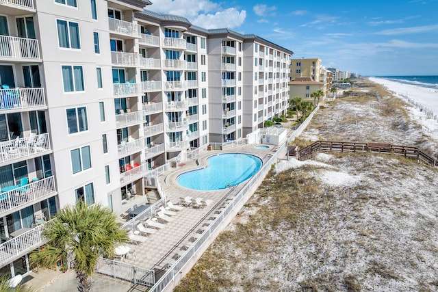 view of swimming pool with a water view and a view of the beach