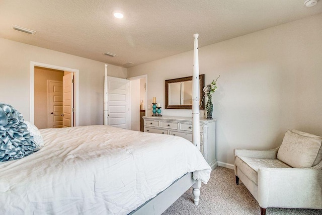 bedroom with a textured ceiling and light carpet