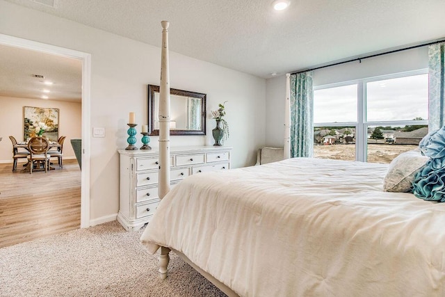 bedroom featuring light colored carpet and a textured ceiling