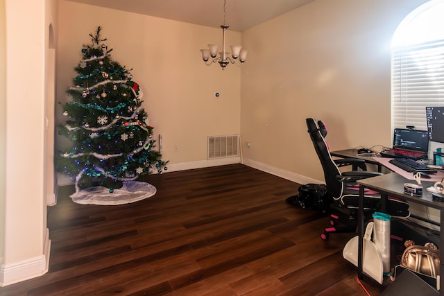 home office featuring dark hardwood / wood-style flooring and a notable chandelier