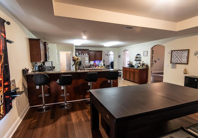 dining room with sink and dark wood-type flooring