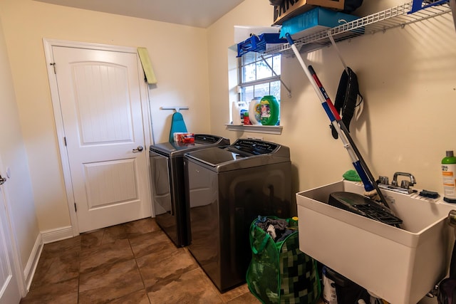 clothes washing area with tile patterned flooring, separate washer and dryer, and sink