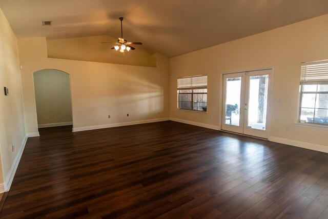 spare room featuring arched walkways, dark wood finished floors, lofted ceiling, ceiling fan, and french doors