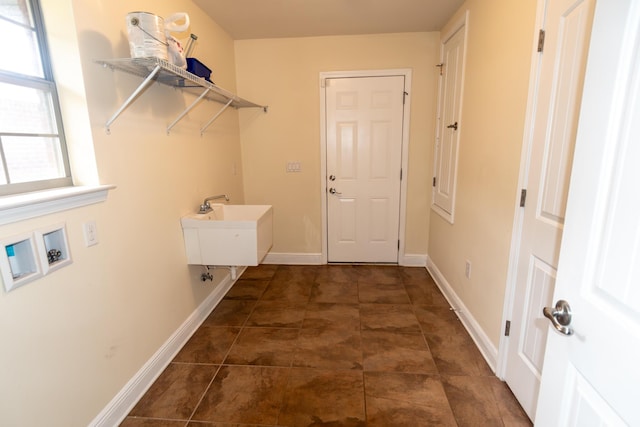 laundry area featuring hookup for a washing machine, a sink, dark tile patterned flooring, laundry area, and baseboards