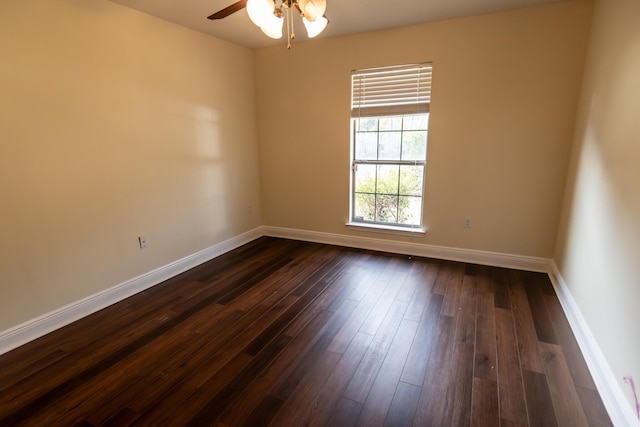 empty room featuring dark wood-style floors, baseboards, and a ceiling fan