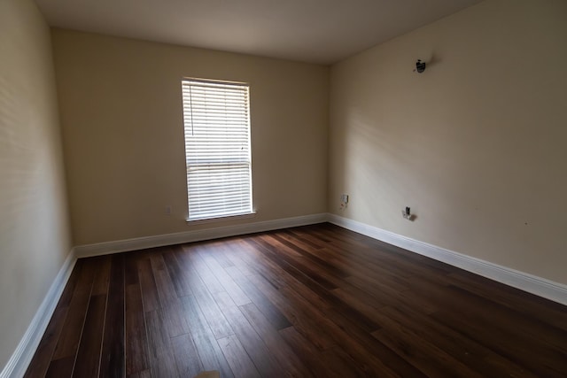 unfurnished room with dark wood-style floors and baseboards