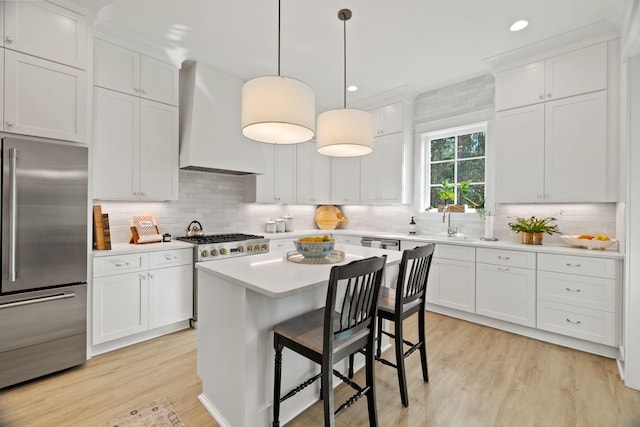 kitchen with white cabinetry, hanging light fixtures, stainless steel built in refrigerator, a kitchen island, and custom range hood