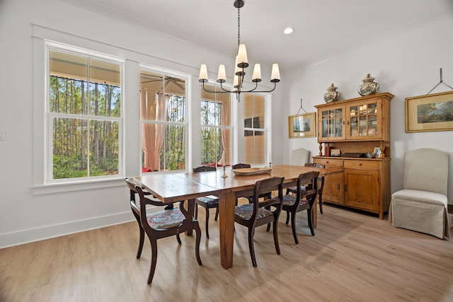 dining space with light hardwood / wood-style flooring, a chandelier, and ornamental molding