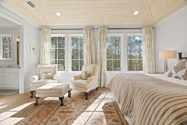 bedroom featuring ensuite bathroom, wooden ceiling, lofted ceiling, and light wood-type flooring