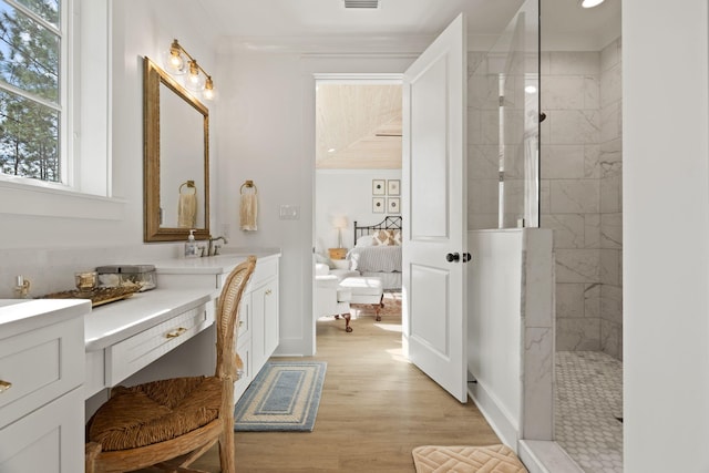 bathroom featuring a tile shower, hardwood / wood-style floors, and vanity