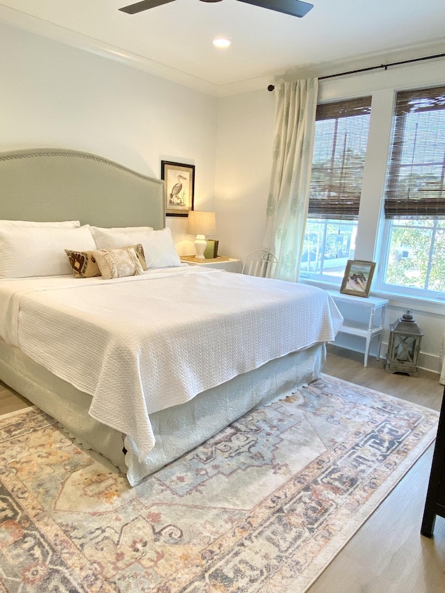 bedroom featuring ceiling fan, crown molding, and hardwood / wood-style flooring