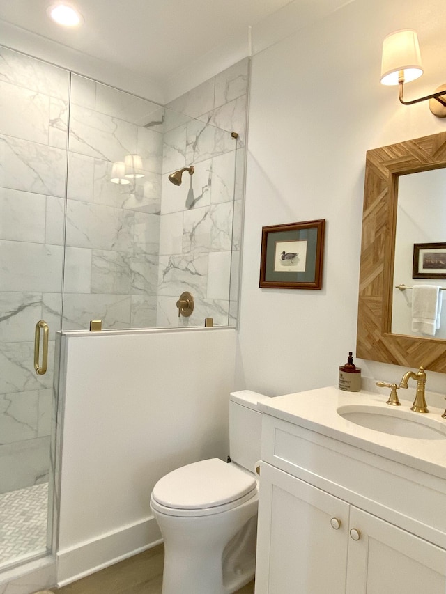 bathroom featuring hardwood / wood-style flooring, vanity, toilet, and walk in shower