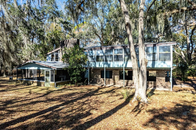 back of property featuring a sunroom and a yard