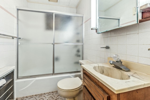 full bathroom with enclosed tub / shower combo, tile walls, backsplash, vanity, and toilet