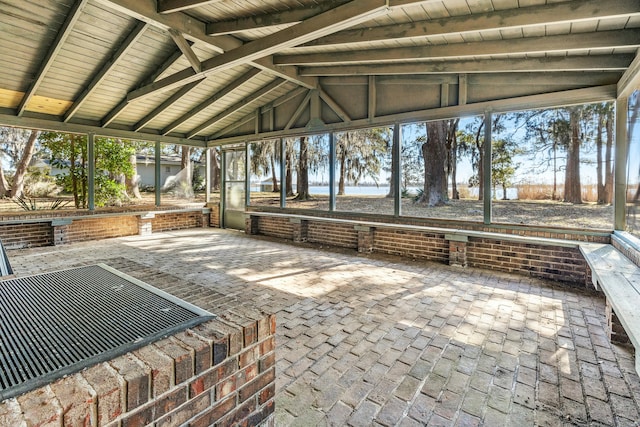 unfurnished sunroom featuring vaulted ceiling, a wealth of natural light, and wooden ceiling