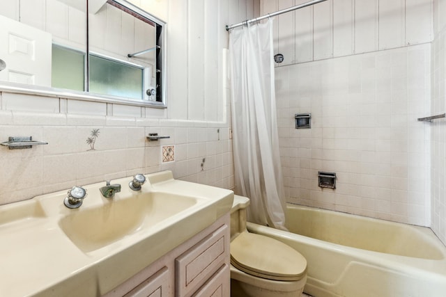 full bathroom featuring shower / tub combo with curtain, vanity, tile walls, and toilet