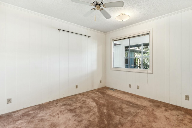 spare room with ceiling fan, ornamental molding, carpet, and a textured ceiling