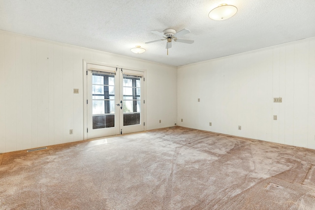 unfurnished room with ornamental molding, light colored carpet, ceiling fan, a textured ceiling, and french doors