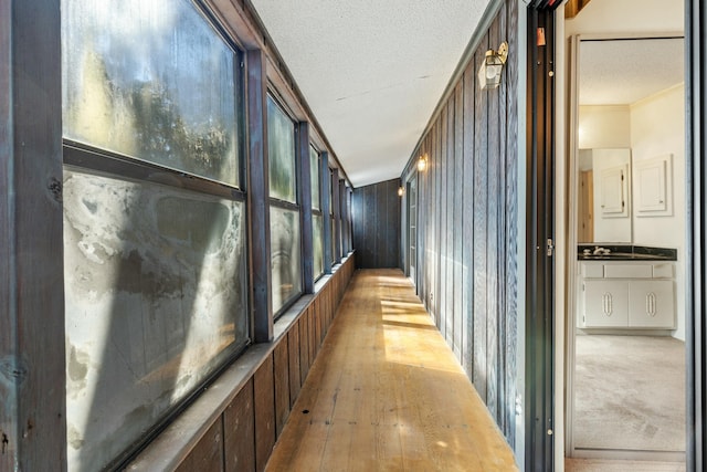 hall featuring hardwood / wood-style floors, crown molding, and a textured ceiling