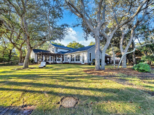 rear view of house with a pergola and a lawn