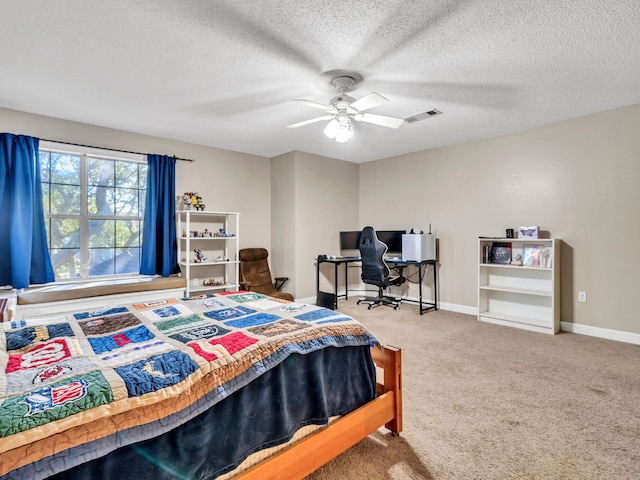 carpeted bedroom with ceiling fan and a textured ceiling