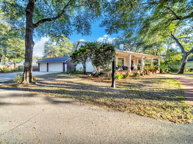 view of front facade featuring covered porch, a garage, and an outdoor structure