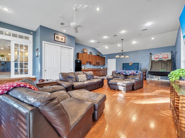 living room featuring light wood-type flooring, ceiling fan, and lofted ceiling