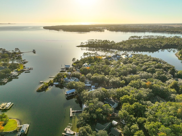 aerial view at dusk featuring a water view