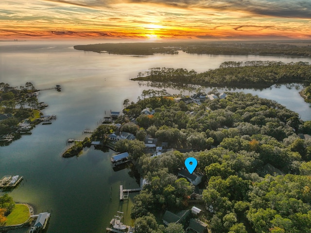 aerial view at dusk featuring a water view