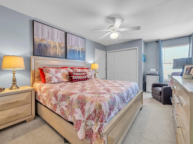 bedroom with a closet, light colored carpet, and ceiling fan