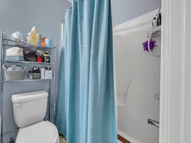 bathroom featuring curtained shower and toilet