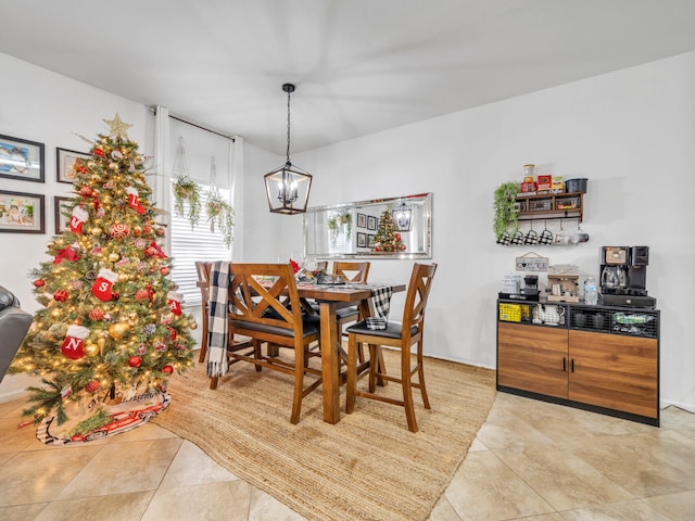 dining space featuring light tile patterned flooring and a notable chandelier