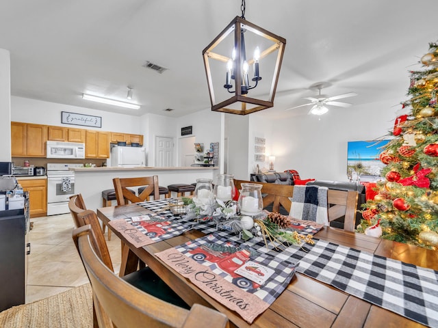 dining room with light tile patterned floors and ceiling fan with notable chandelier