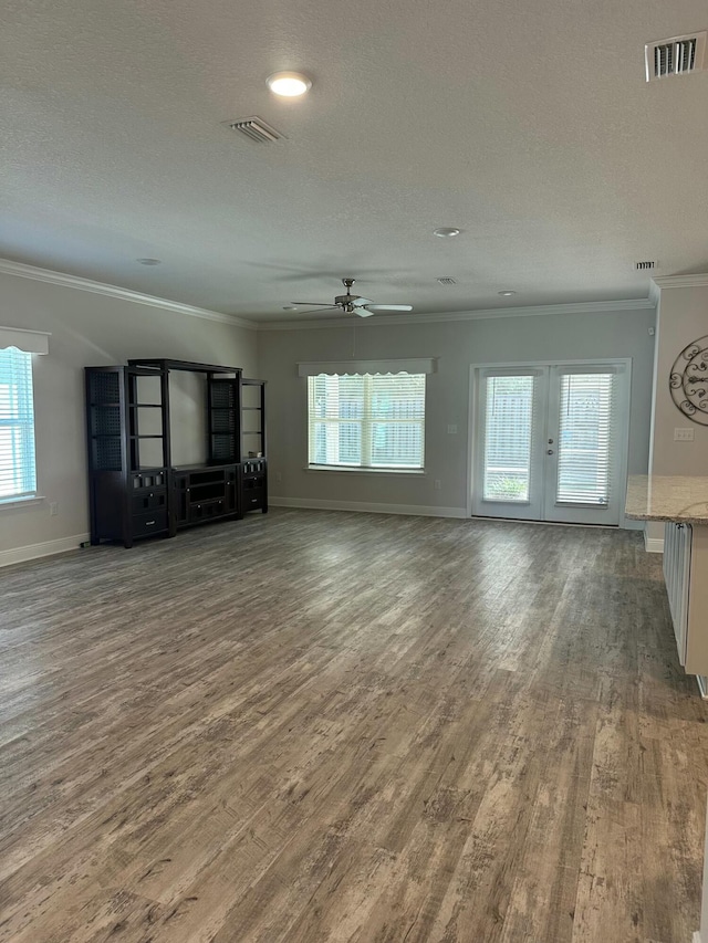 unfurnished living room with ceiling fan, dark hardwood / wood-style flooring, ornamental molding, and a textured ceiling