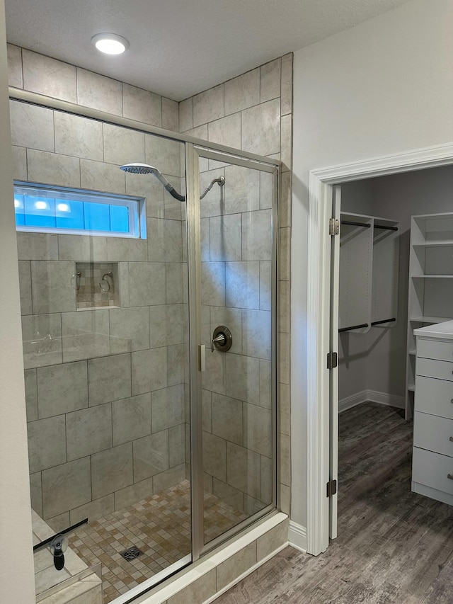 bathroom with wood-type flooring and an enclosed shower