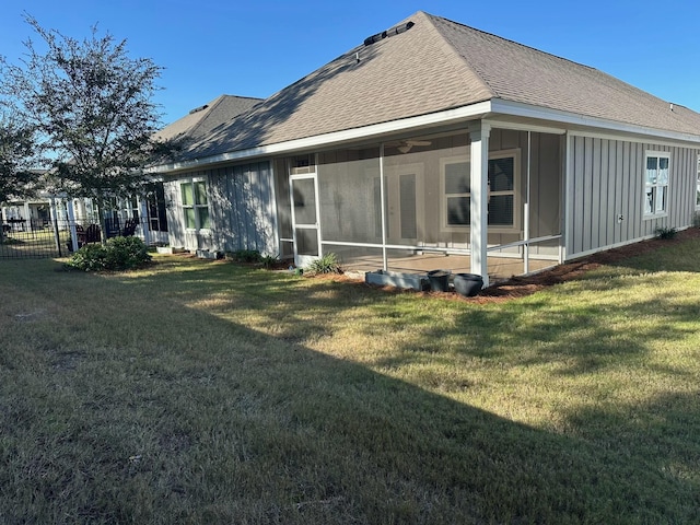 rear view of house with a lawn and a sunroom