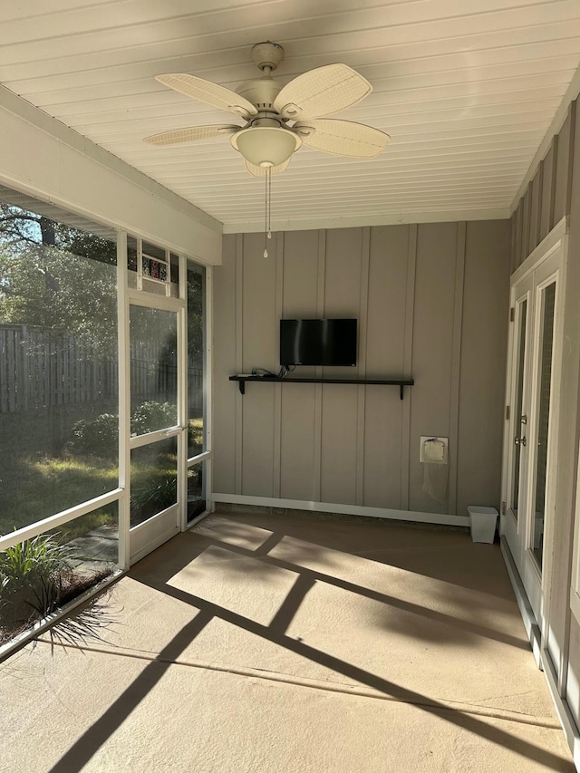 unfurnished sunroom featuring ceiling fan