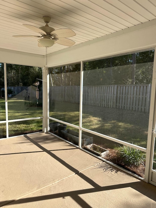 unfurnished sunroom with ceiling fan