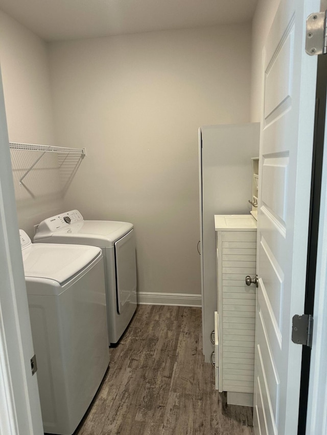 washroom with separate washer and dryer and dark wood-type flooring