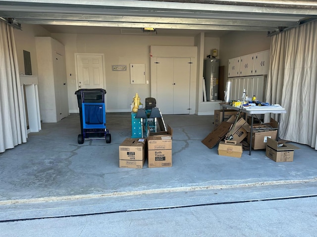 garage with electric panel, a garage door opener, and water heater