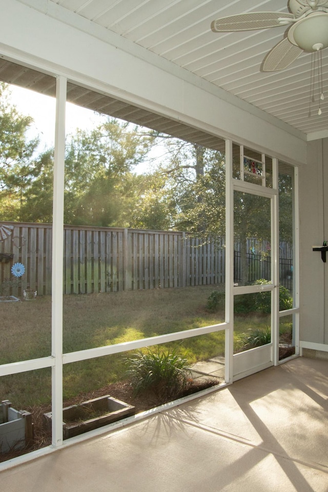 unfurnished sunroom with ceiling fan