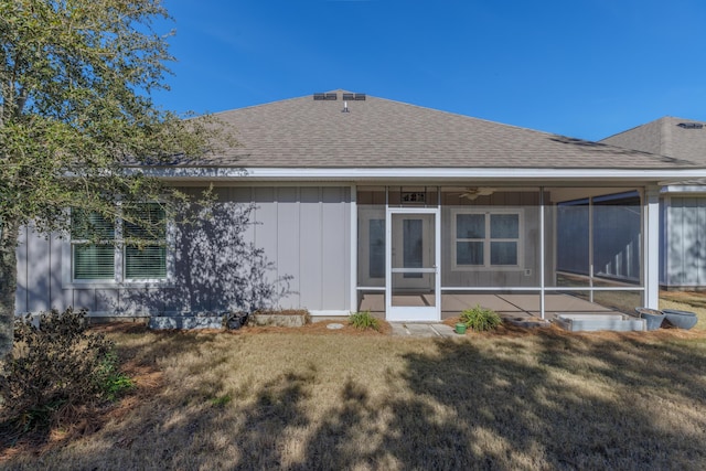 rear view of property with a sunroom and a lawn