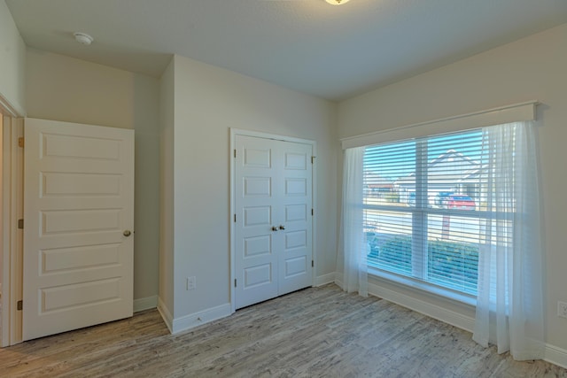 unfurnished bedroom with a closet and light hardwood / wood-style flooring