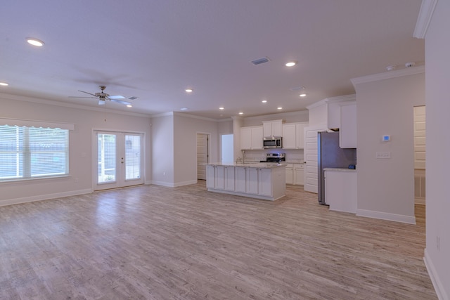 kitchen with white cabinetry, ornamental molding, a kitchen island with sink, and light hardwood / wood-style flooring