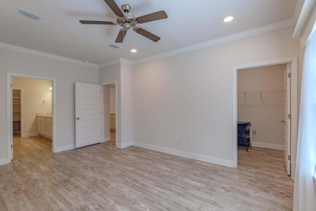 unfurnished bedroom with crown molding, a walk in closet, and ceiling fan