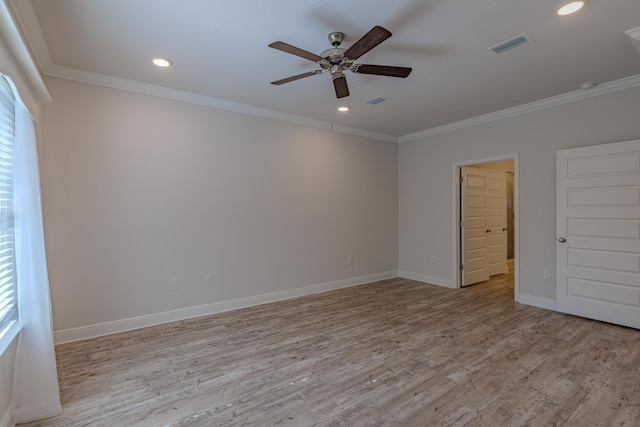 empty room featuring crown molding and light hardwood / wood-style floors