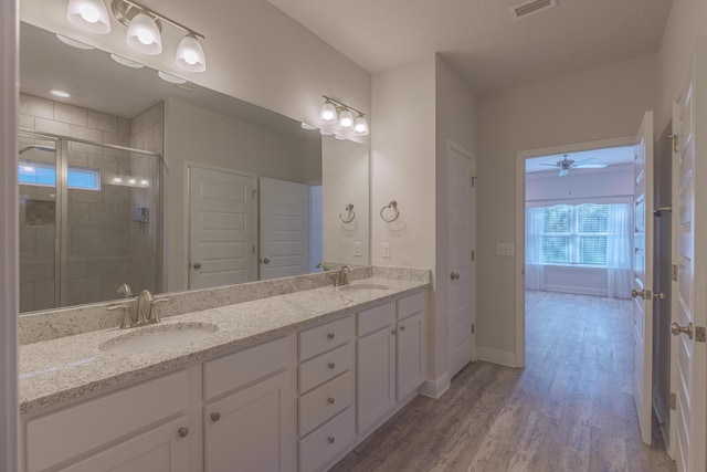 bathroom with vanity, hardwood / wood-style floors, a shower with shower door, and ceiling fan