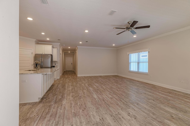 unfurnished living room featuring ornamental molding, sink, ceiling fan, and light hardwood / wood-style floors