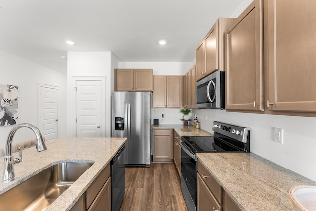 kitchen with light stone countertops, sink, dark hardwood / wood-style floors, and appliances with stainless steel finishes