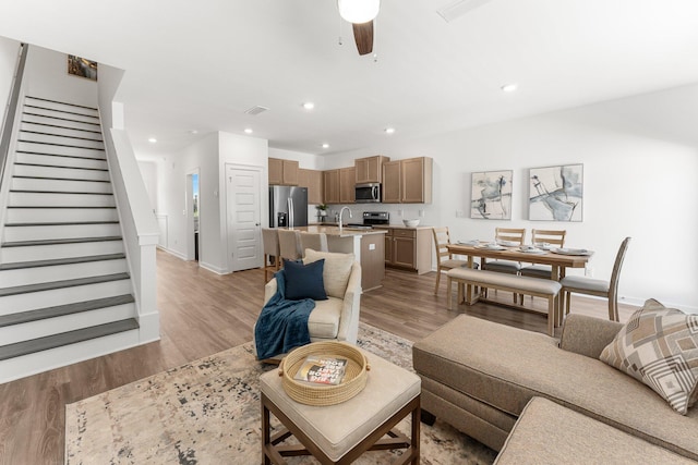 living room with ceiling fan and light hardwood / wood-style floors